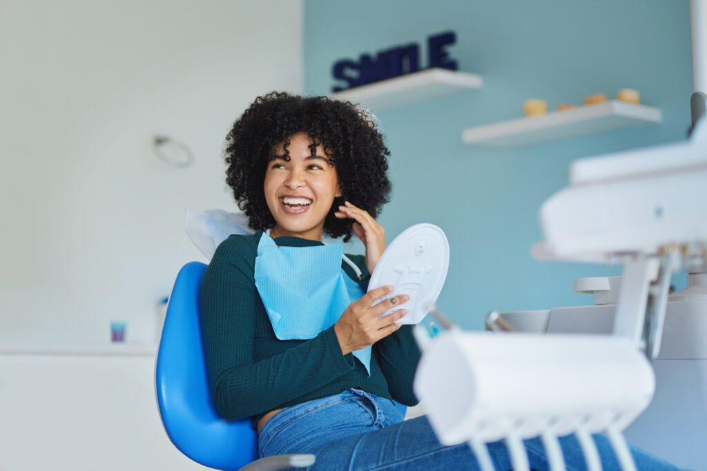 a girl in a dental clinic sitting on a clinic chair while smiling